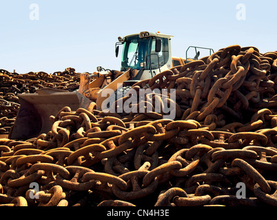 Rusted chains and excavator in scrap yard Stock Photo