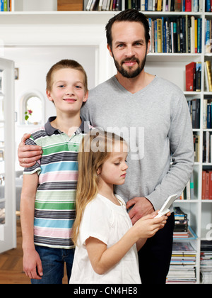 Father and family standing together in living room, portrait Stock Photo
