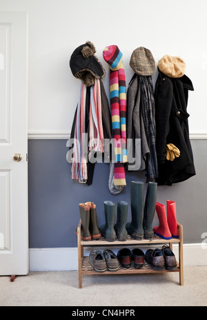 Coats and hats hanging on wall in hallway Stock Photo