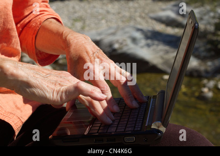 Close-up of senior woman using netbook. Stock Photo