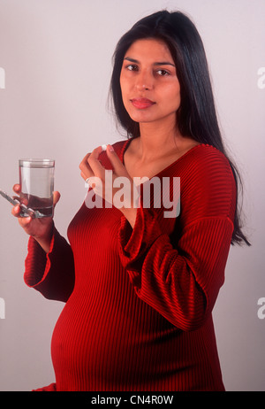 pregnant woman taking a pill Stock Photo
