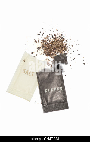 Opened sachets of salt and pepper Stock Photo