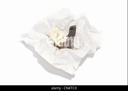 Opened sachets of salt and pepper on a paper serviette Stock Photo