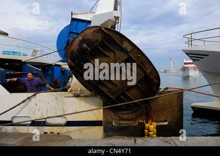 France, Herault, Sete, Vieux Port (Old harbour), docking activity on the wharf of the fish auction market and the lighthouse of Stock Photo