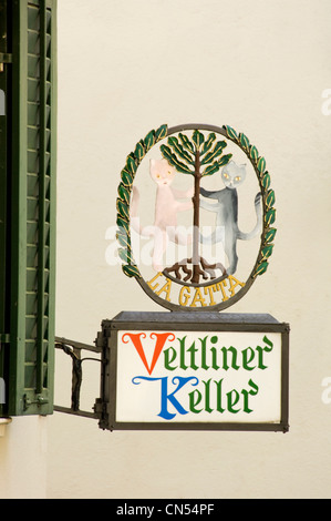 Vertical close up of an old decorative wrought iron sign hanging outside a pub in Lindenhof in Zurich's old town on a sunny day. Stock Photo