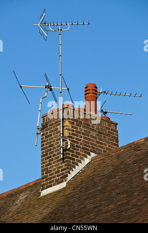 TV aerials on a brick chimney stack on the roof of a house, London, England, UK. Stock Photo