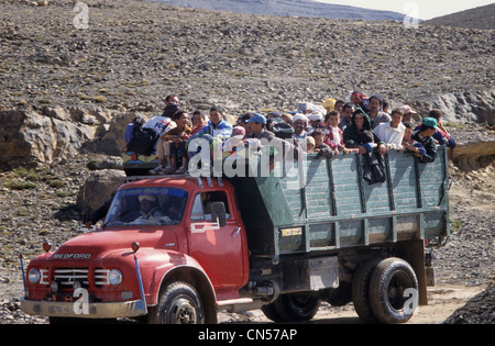 Moroccan group of people traveling in the back of a truck in the Atlas, Morocco Stock Photo