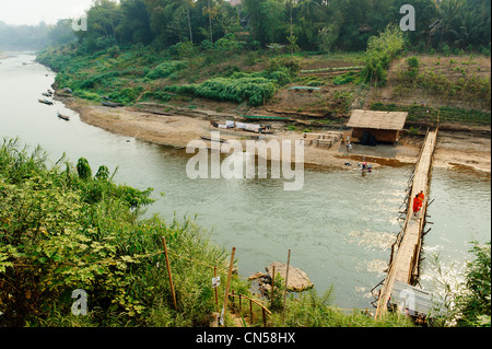 Laos, Luang Prabang Province, Luang Prabang City, Nam Khan River, monks crossing a wooden bridge Stock Photo