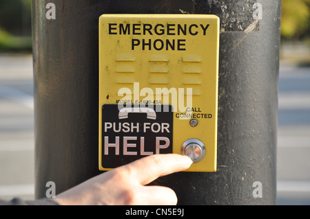 Pushing emergency phone for help Stock Photo