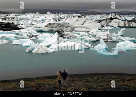 Iceland, Austurland Region, couple in front of the Jokulsarlon Glacial Lake and its icebergs Stock Photo