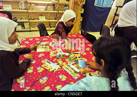 Sultanate of Oman, Muscat, elevated view of school kids looking at photographs Stock Photo