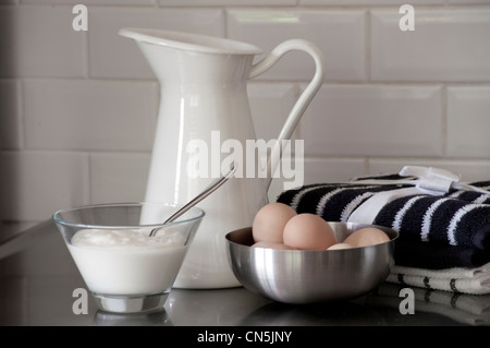 Milk jug and bowl of eggs with a bowl of yoghurt. Stock Photo