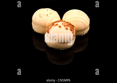 White Belgian pralines isolated on black Stock Photo