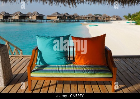 Maldives, South Male Atoll, Veligandu Island, Veli Resort and Spa Hotel, bench cushions beside a white sand beach and bungalows Stock Photo