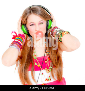 young teen girl listening to music on headphones and blowing gum Stock Photo
