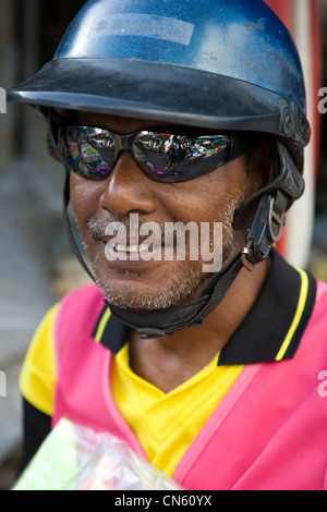 A motorcycle taxi driver waiting for trade outside the Central market Songkhla, Thailand Stock Photo
