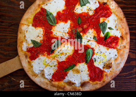 A basic Italian pizza Margherita with mozzarella, tomato sauce, and fresh basil Stock Photo