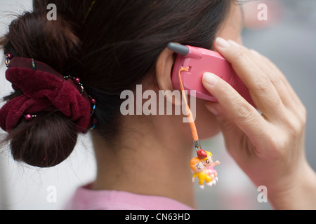 A young woman speaks on her mobile phone, Bangkok, Thailand Stock Photo