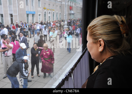 Woman looking out of train window as it leaves Ulaanbaatar Station, Mongolia Stock Photo