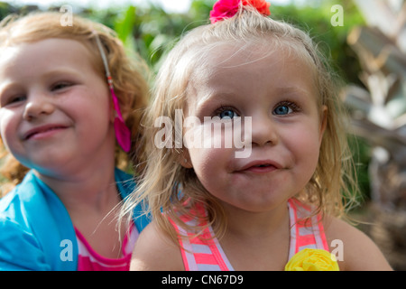 Portrait of sisters playing happy in a backyard, caucasian childs. Stock Photo