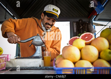 Local fresh juice vendor squeezing oranges, Essaouira, Morocco. Stock Photo