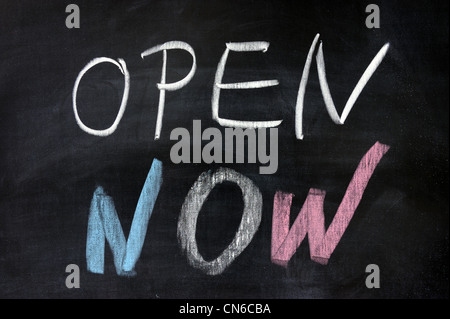 Chalk drawing - 'open now' words written on chalkboard Stock Photo