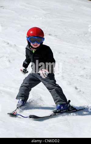 A young boy skiing on the piste by himself Stock Photo