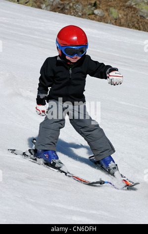 A young boy skiing on the piste by himself Stock Photo