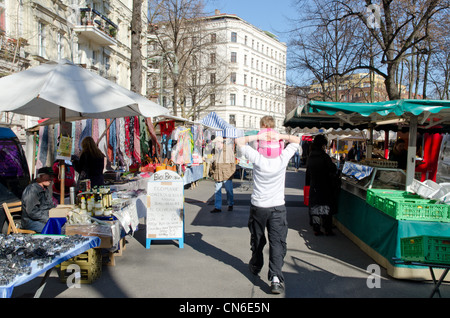 Man carrying child through market in Kollwitzplatz square in Prenzlauer Berg district of eastern Berlin Stock Photo