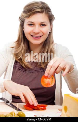 Young happy beautiful woman cutting fresh tomatoes, isolated on white background. Stock Photo