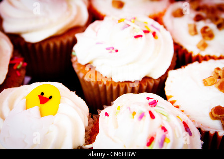 A selection of decorated iced cupcakes on sale at Warrington market Stock Photo