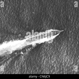 Chikuma (Japanese Heavy Cruiser, 1939) under air attack during the Battle of the Santa Cruz Islands, 26 October 1942. Photographed from a USS Enterprise (CV-6) plane. Note the smoke coming from her bridge area, which had been hit by a bomb, and what appears to be a recognition marking painted atop her number two eight-inch gun turret. The ship's catapults and aircraft crane appear to be swung out over her sides, aft of amidships. Stock Photo