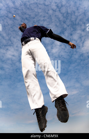 baseball player jumping and catching the ball Stock Photo