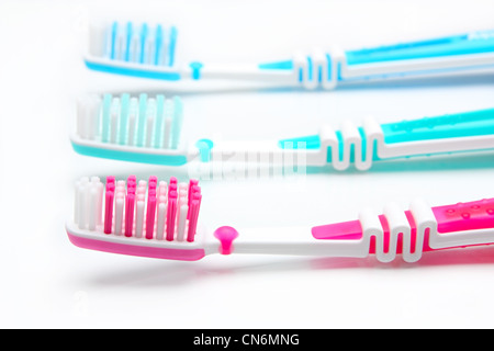 Three toothbrushes red, green and blue on a white background Stock Photo