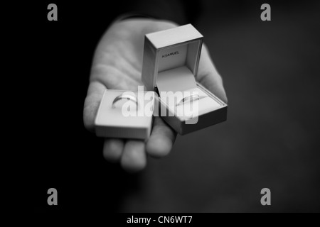 Black and white image of a groom holding rings for his wedding. Stock Photo