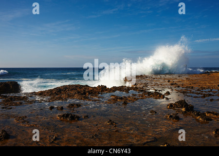 Large waves breaking on the rocky shore, a lot of foam, a lot of spray, a powerful energy Stock Photo