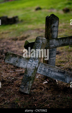 Fallen wooden crosses in an old cemetery. Stock Photo