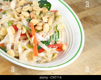 Thai Rice Noodle Salad in a bowl sitting on a wooden table. Stock Photo