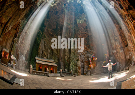 Marble Mountains, Tourist posing in ray of light illuminating Huyen Khong cave. Danang, Vietnam Stock Photo