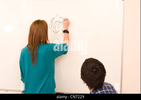 Girl drawing a cartoon on the classroom board Stock Photo