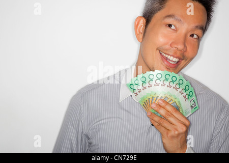 Portrait of chinese asian man holding money and smiling Stock Photo