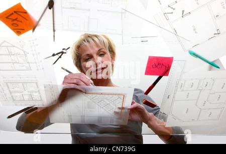 Architect working on a table in architectural drawings. Stock Photo