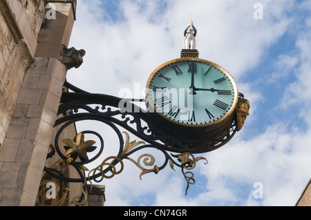 Low angle view of historic Little Admiral Clock (hands at 3.00pm) bracketed high on stone exterior wall of church - York, North Yorkshire, England, UK Stock Photo