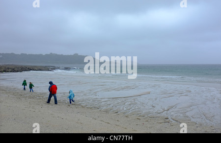 A family on Gyllyngvase beach  in Cornwall on a wet and windy day Stock Photo