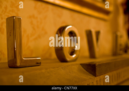 Silver metal letters spelling the word Love on a mantle piece at a wedding Stock Photo