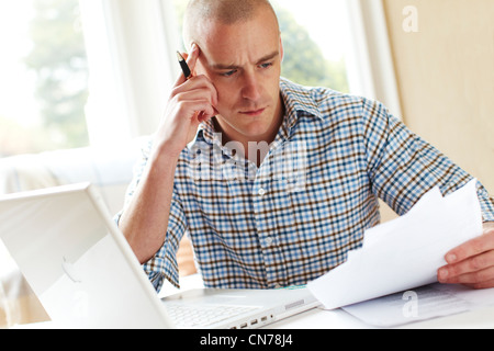 Male working out finances Stock Photo