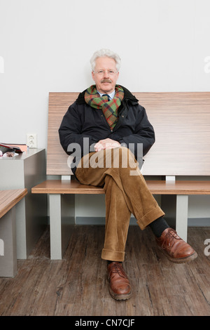 elderly man, sitting patiently in the waiting room of a medical practice, waiting for his turn Stock Photo