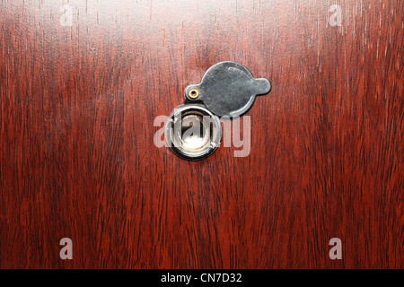 Peephole on wooden door - judas hole spyhole Stock Photo