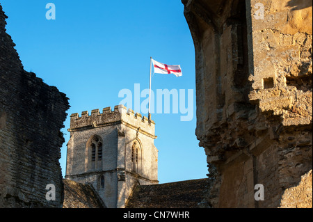 Looking through the old ruins of Minster Lovell Hall to St. Kenelm's Parish Church, Minster Lovell. Stock Photo