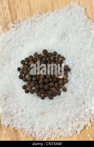 black peppercorns on top of rock salt